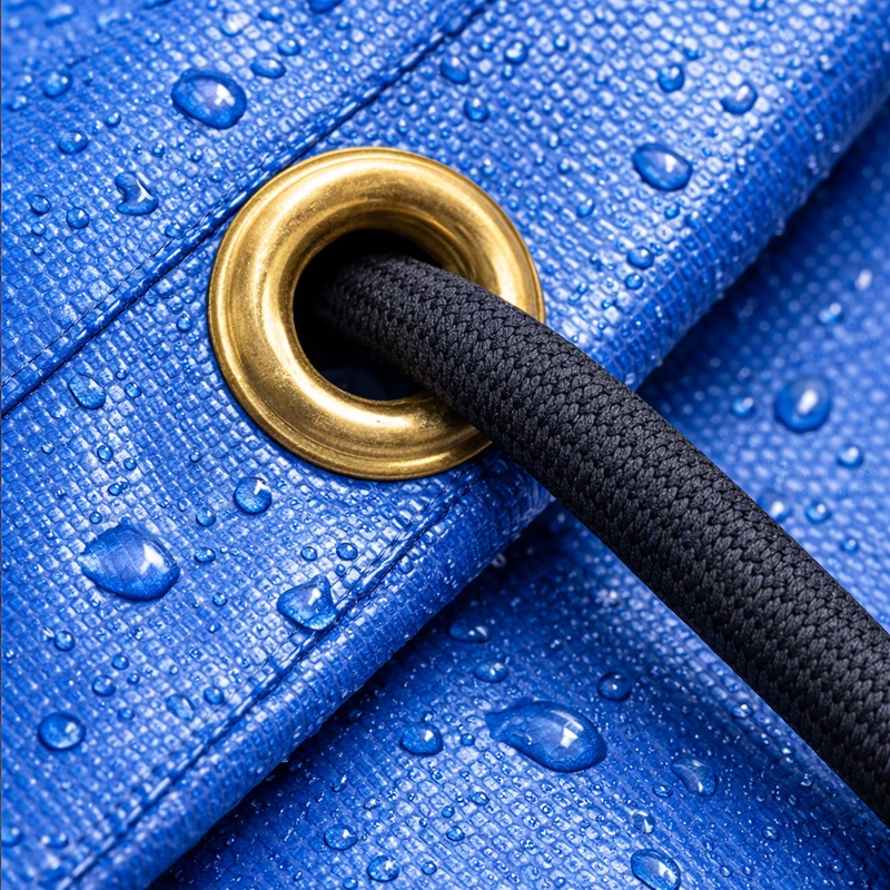 Œillet métallique serti dans un ourlet renforcé de toile PVC noire, double couture visible